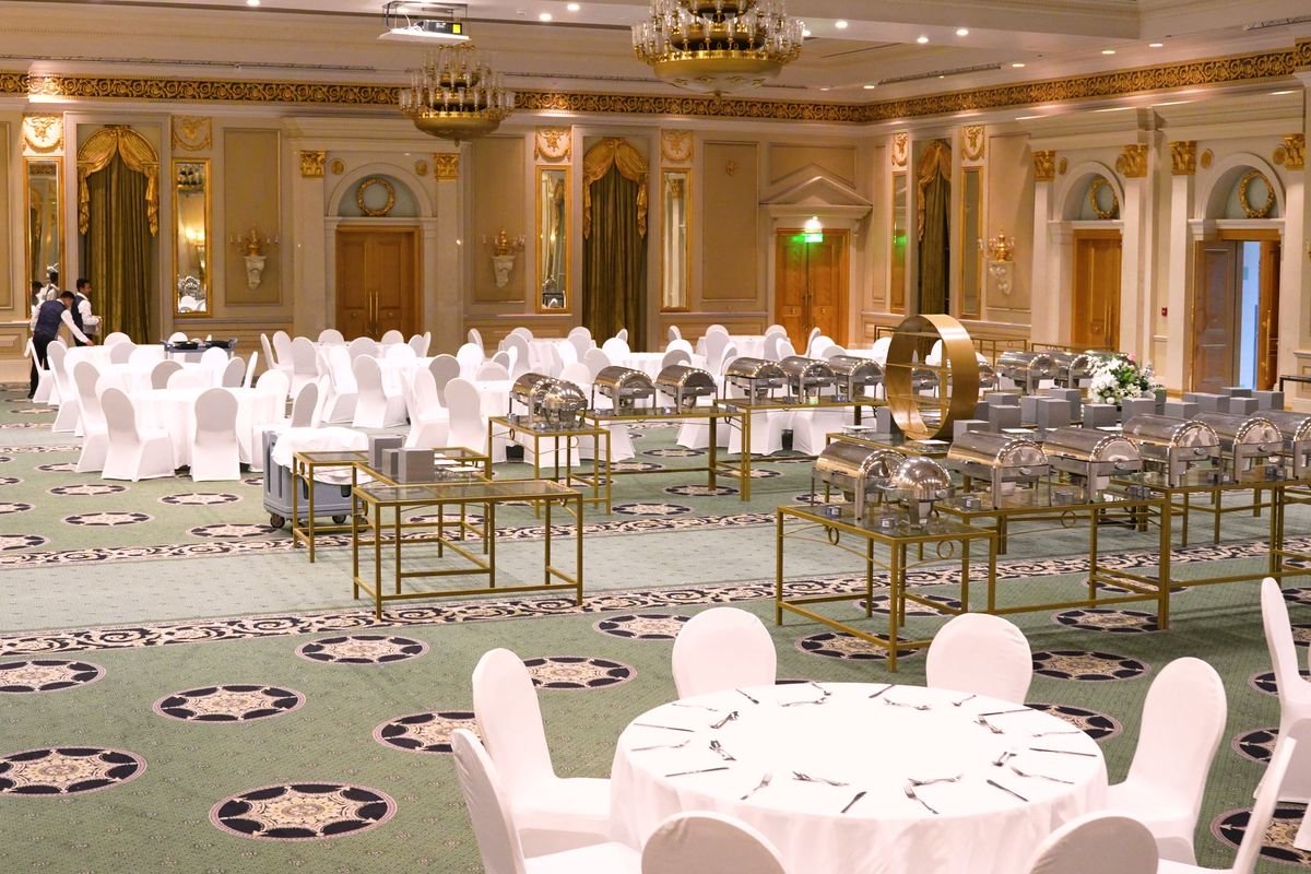 Round tables set across a gold-detailed ballroom